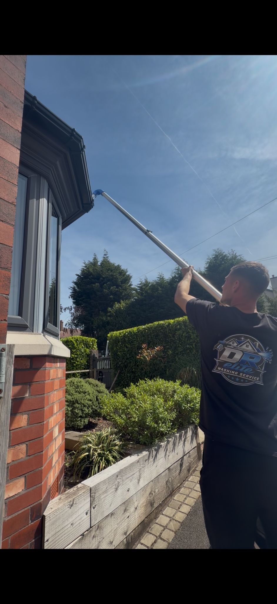 DR Elite clearing a gutter with a reach-and-vacuum pole from the ground